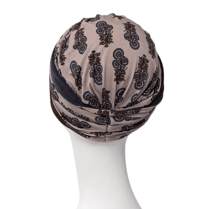 Shakti turban in beige with dark paisley pattern, back view on mannequin with an elegant knot at the back