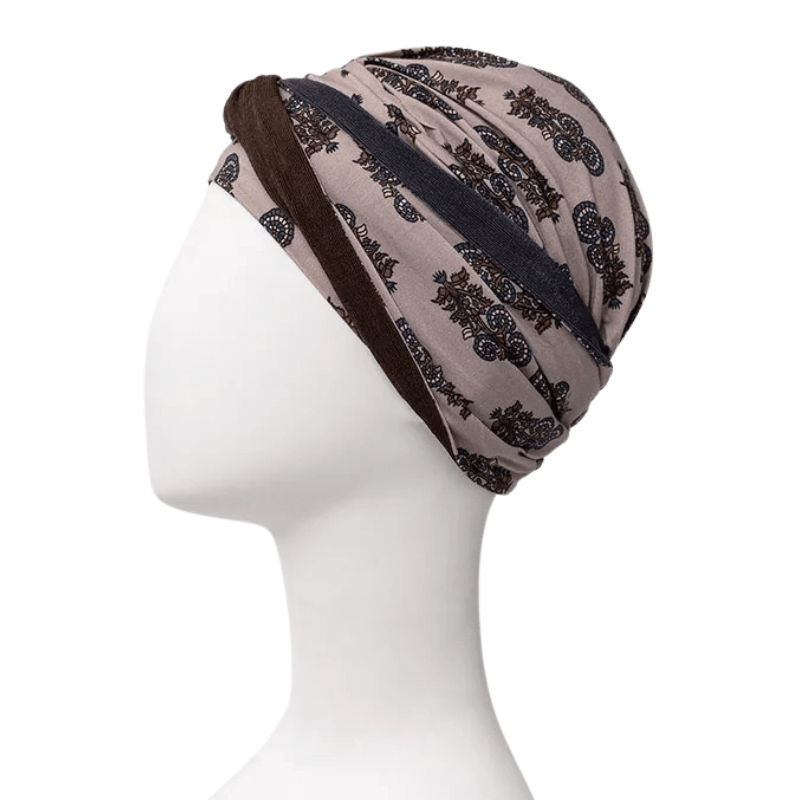 Shakti turban in beige with dark paisley print, side view on mannequin, headband along the neck