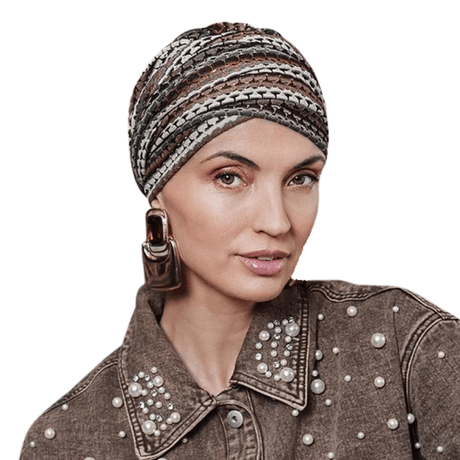 Woman wearing Sapphire Boho turban with knitted pattern in warm striped shades and gold thread