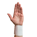 Håndledsbandage i hvidt elastisk materiale båret på et håndled, set fra håndfladen med udstrakte fingre